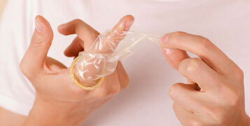 Close,Up,Of,Man,Holding,An,Open,Broken,Condom,With