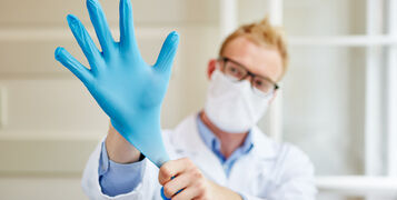 Doctor,Putting,Gloves,On,As,Labor,Protection