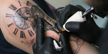 A,Professional,Tattoo,Artist,Introduces,Black,Ink,Into,The,Skin